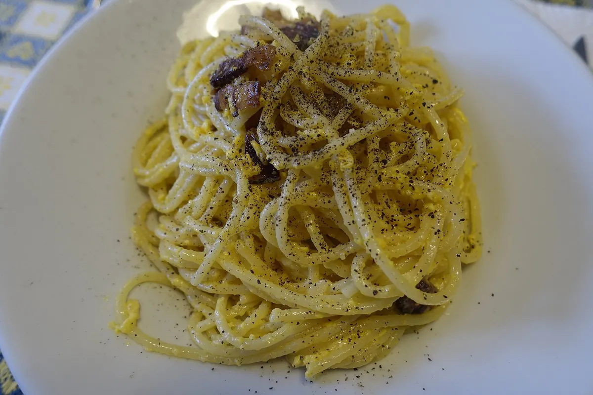 Piatto di spaghetti alla carbonara con guanciale, tuorlo e pepe nero