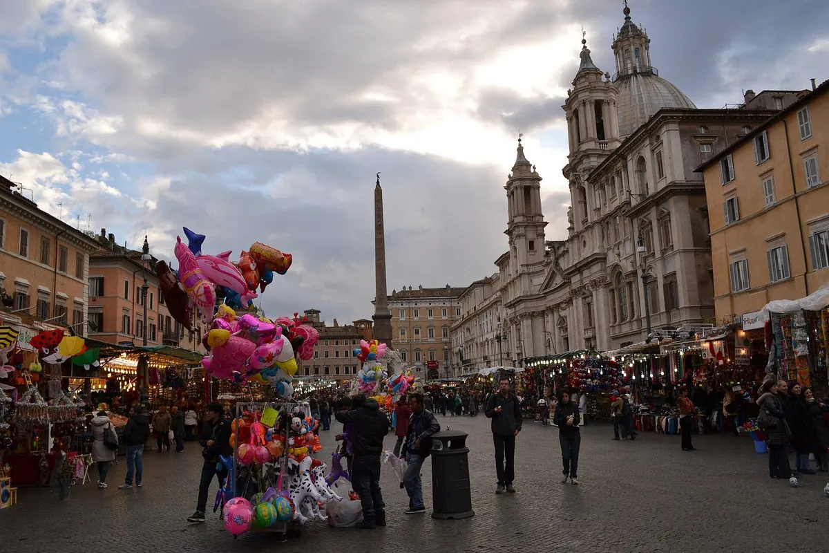 Mercatino di Natale in Piazza Navona con bancarelle, palloncini e la chiesa di Sant'Agnese