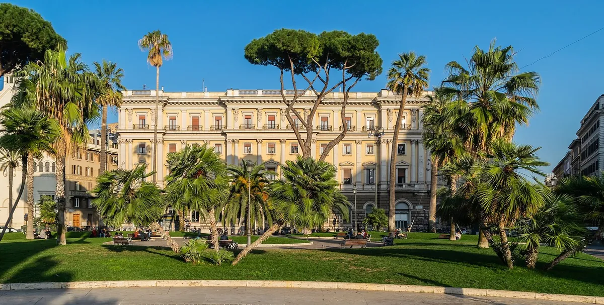 The gardens of Piazza Cavour in the Prati district, with palms, pines and late-19th-century buildings
