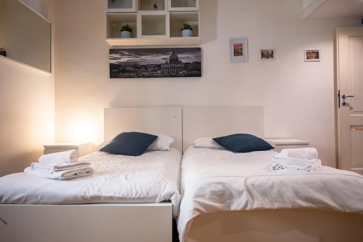 Camera con due letti singoli affiancati e mensole a vista