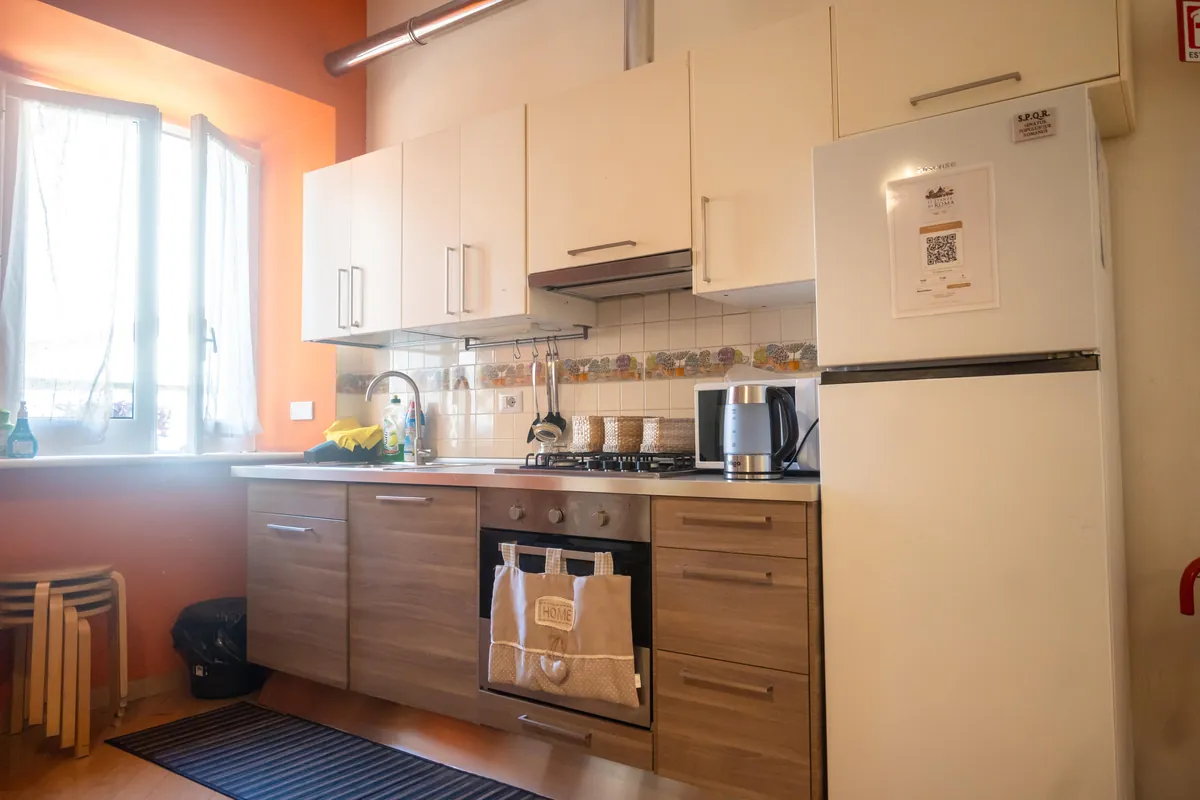 Cucina attrezzata con frigorifero, forno e piano cottura